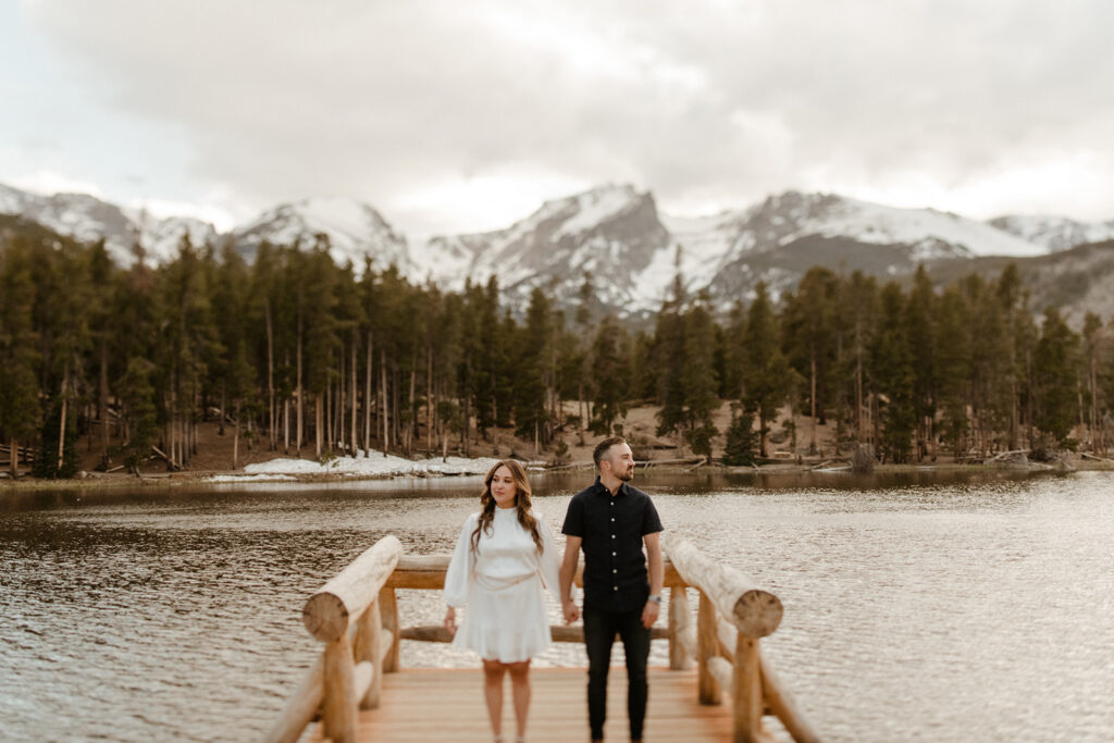 A couple stands on the dock at Sprague Lake in Rocky Mountain National Park