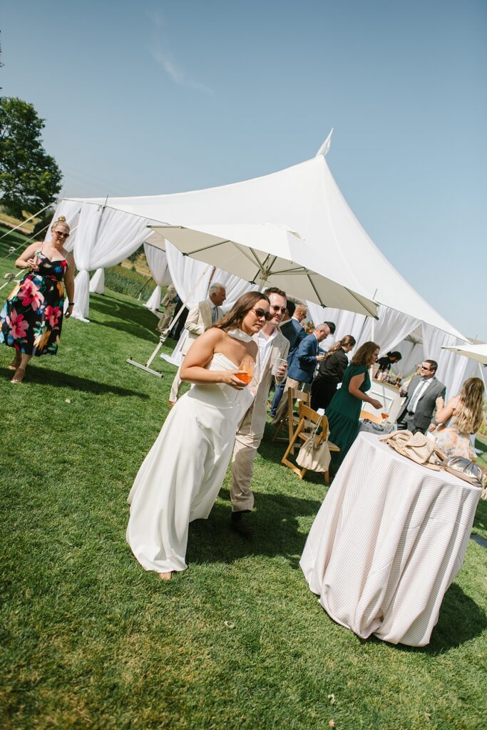 a bride sips aperol spritz during her Boulder Flower Farm wedding cocktail hour