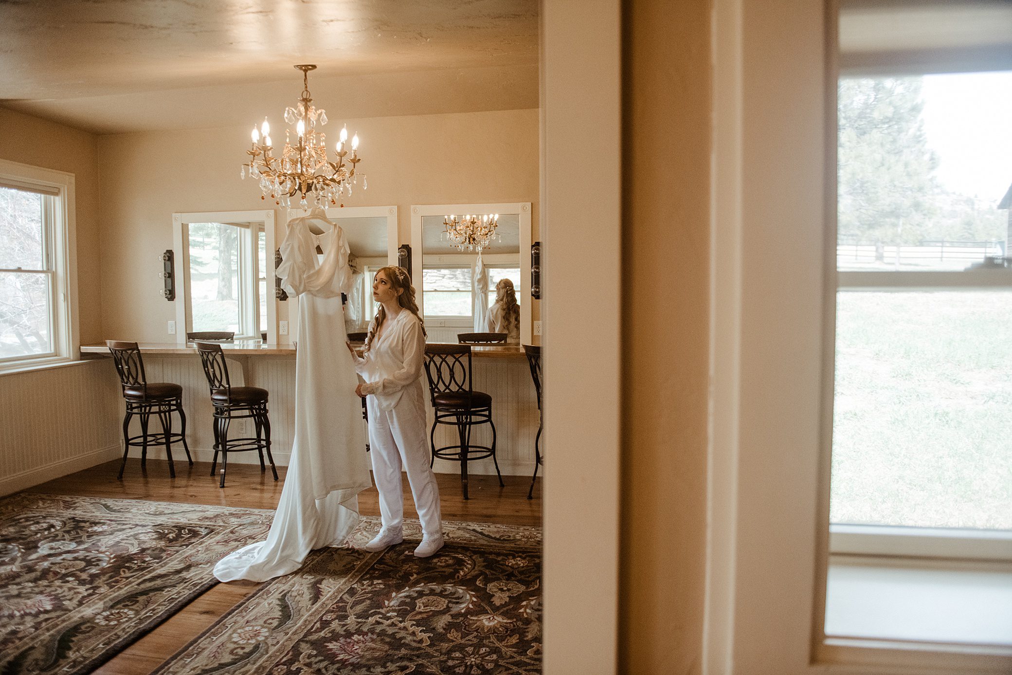 Bride admiring her wedding dress in the getting ready room of Lower Spruce Mountain Ranch