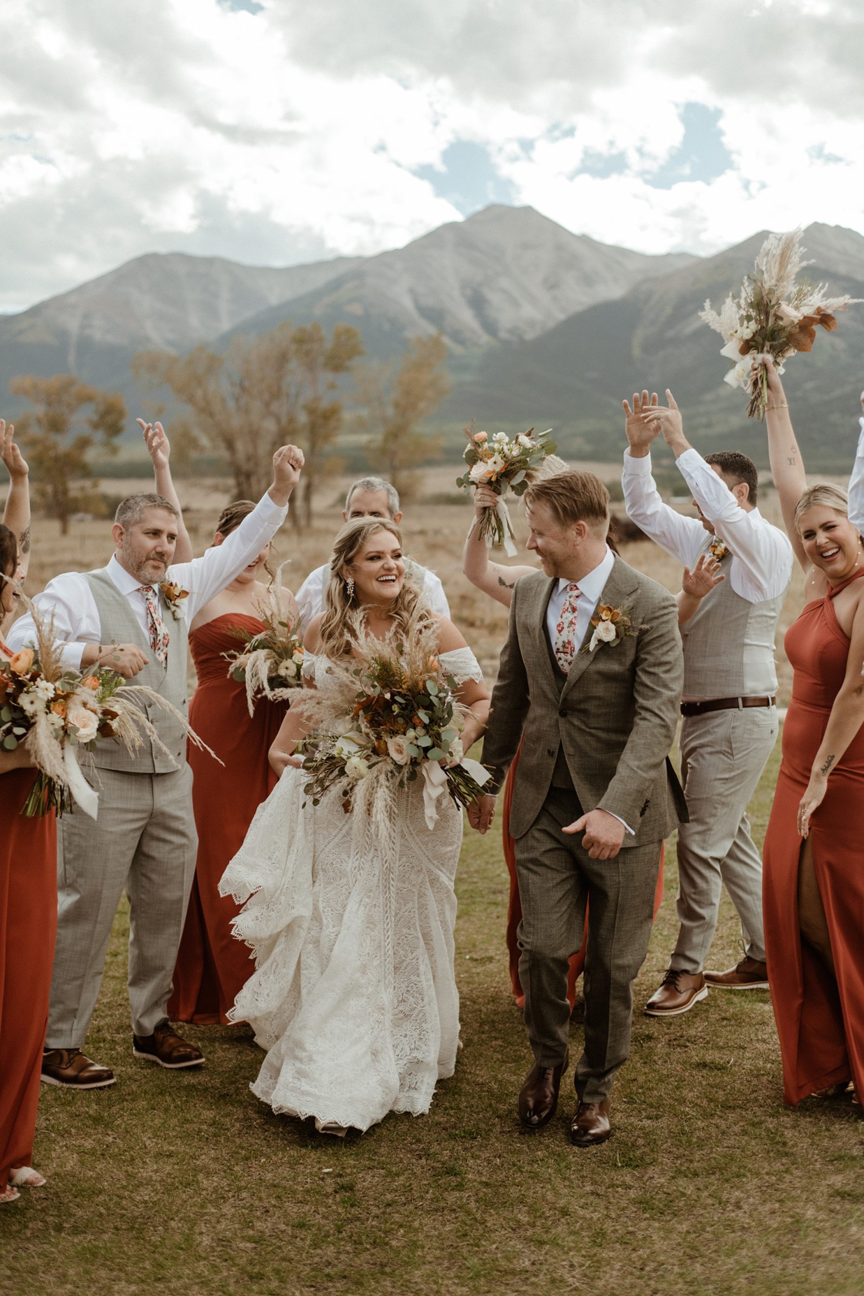 bridesmaids and groomsmen cheer for the bride and groom at the Barn at Sunset Ranch wedding venue in Buena Vista, CO