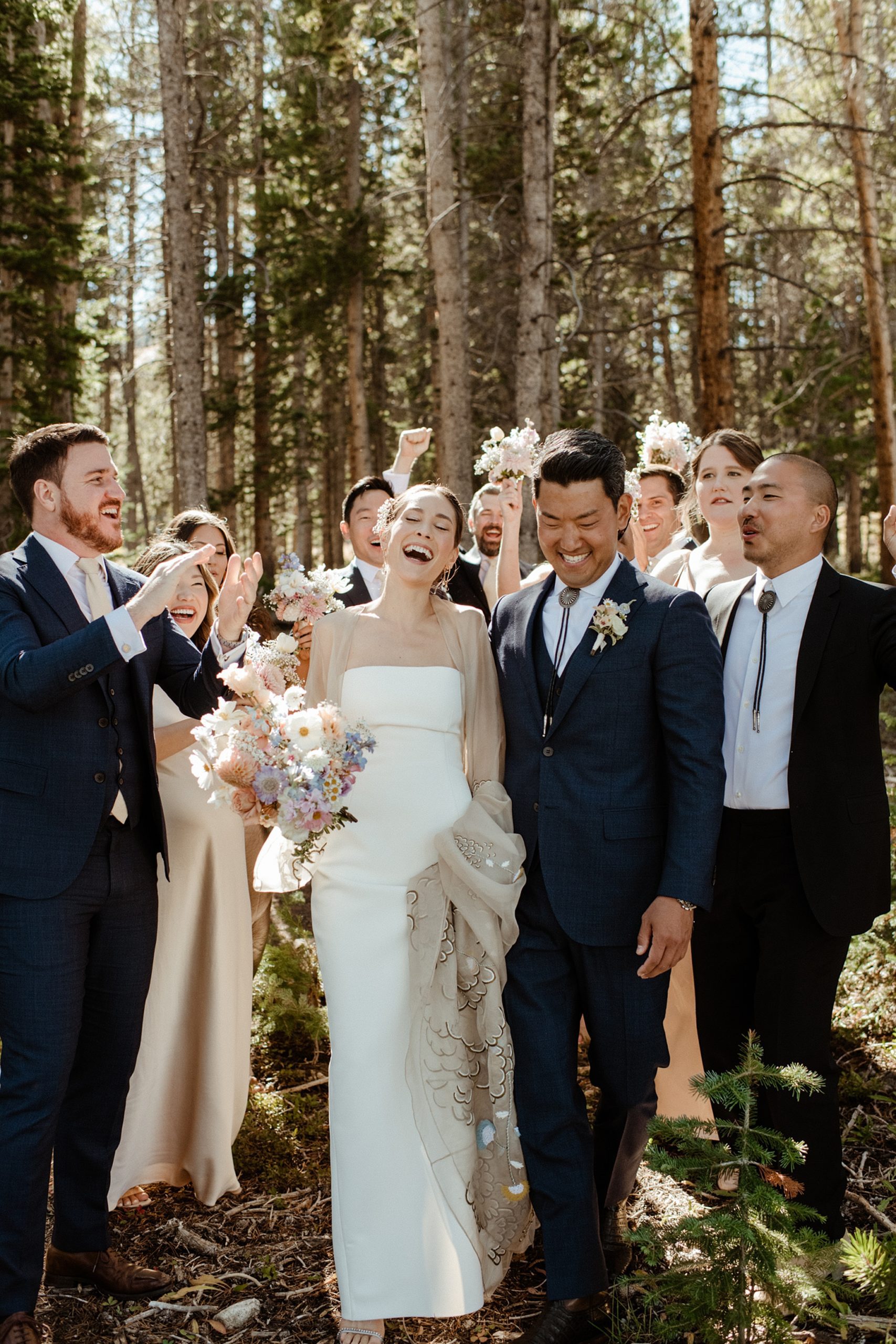 A bride and groom and their wedding party in the woods at Ten Mile Station wedding venue