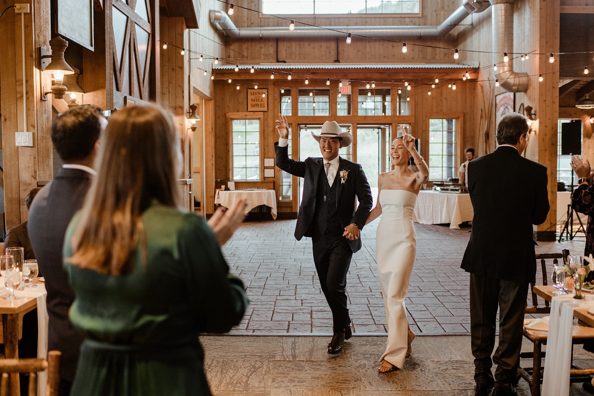 A bride and groom enter their wedding reception at Ten Mile Station in Breckenridge, Colorado