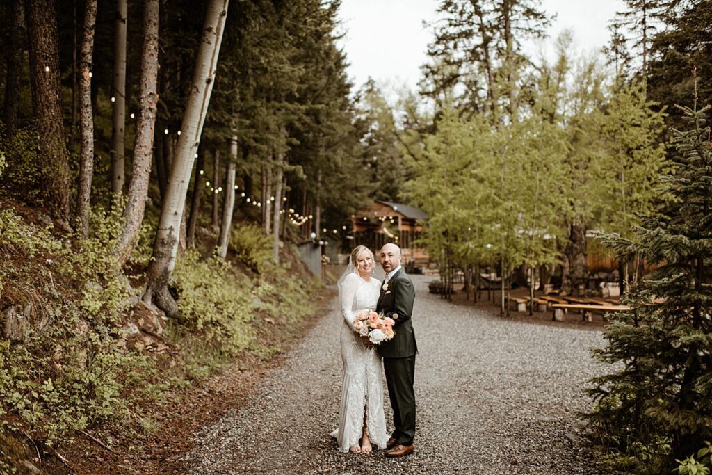A bride and groom on the dirt road lined with market lights of the Blackstone Rivers Ranch wedding venue