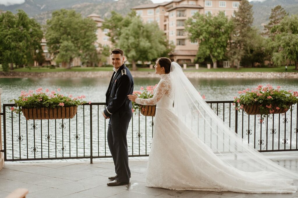 A bride and groom's first look by the lake at the Broadmoor Resort