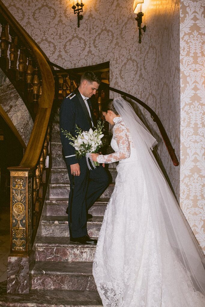 a bride and groom on the main staircase of the Broadmoor Resort