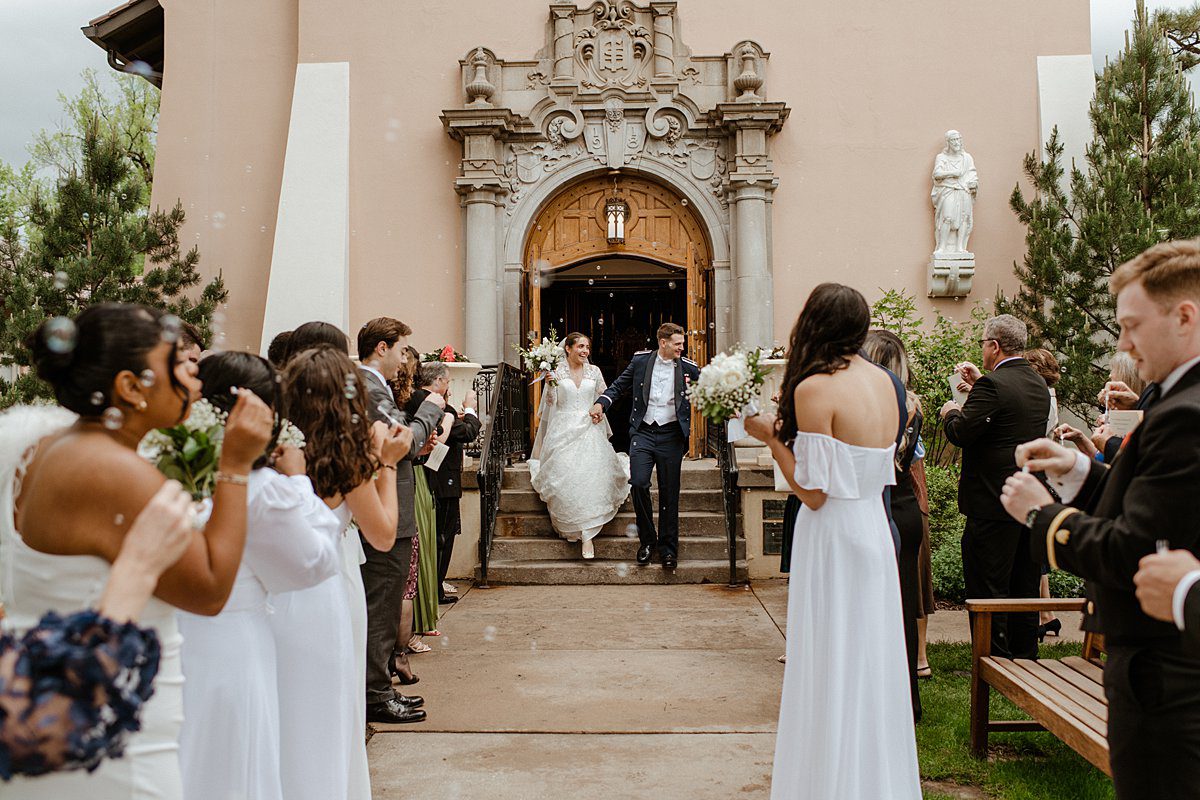 A bride and groom exit the Pauline Chapel front door after their wedding ceremony