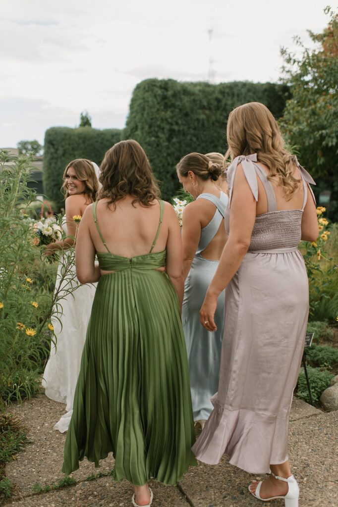 a bride and her bridesmaids walk around the Denver Botanic Gardens during their Annuals Garden and Pavilion wedding 