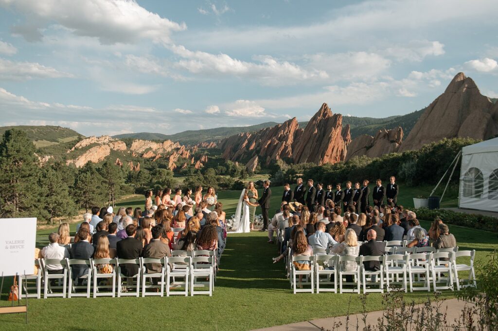 a ceremony at a Arrowhead Golf Course wedding with the view of Roxborough State Park