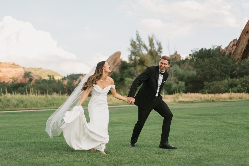 a bride and groom running on the green after their Arrowhead Golf Course wedding