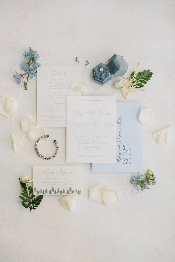 a wedding details flat lay with light blue flowers and accents