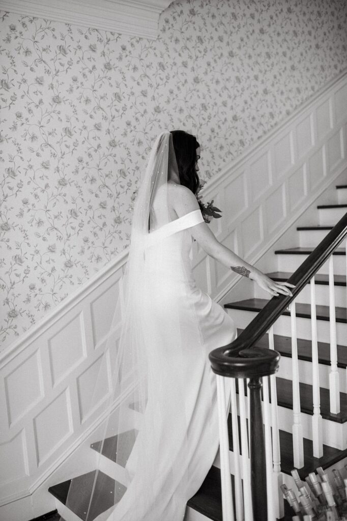 a bride walking up the grand staircase at her Greystone Castle wedding