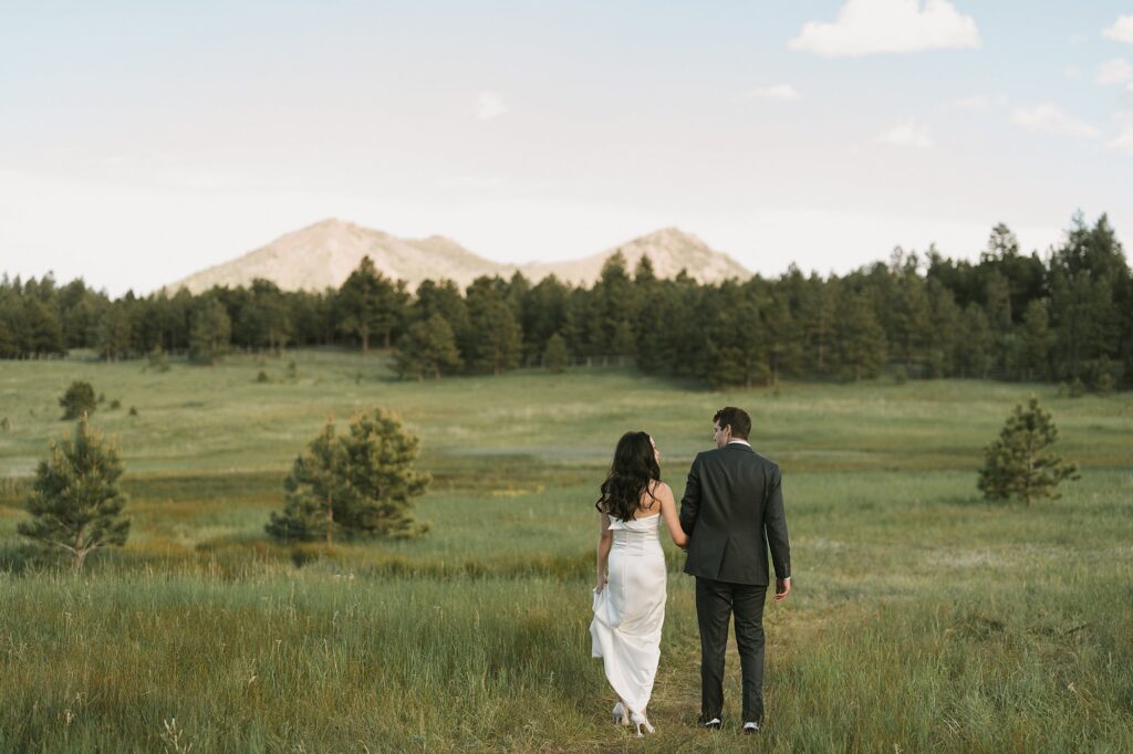 a bride and groom take portraits out in the pasture after their Greystone Castle wedding in Boulder, Colorado