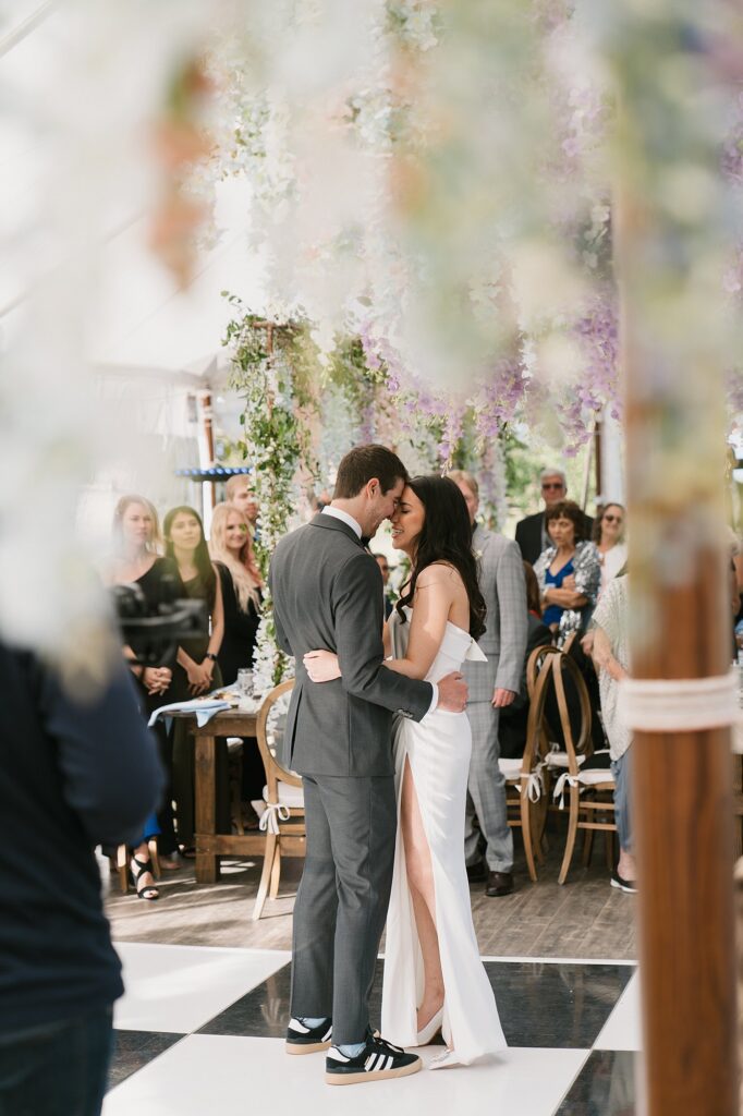 a bride and groom have their first dance inside the reception tent at a Greystone Castle wedding