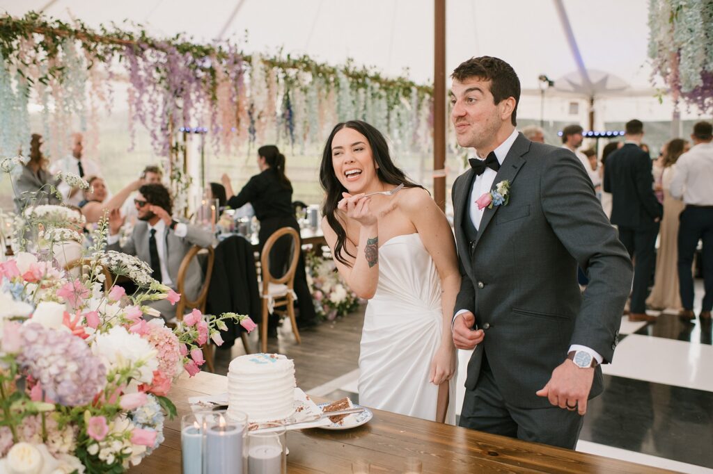 a bride and groom cut their cake inside the reception tent at a Greystone Castle wedding