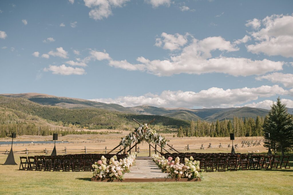A devil's thumb ranch wedding ceremony set up with a lot of summer florals