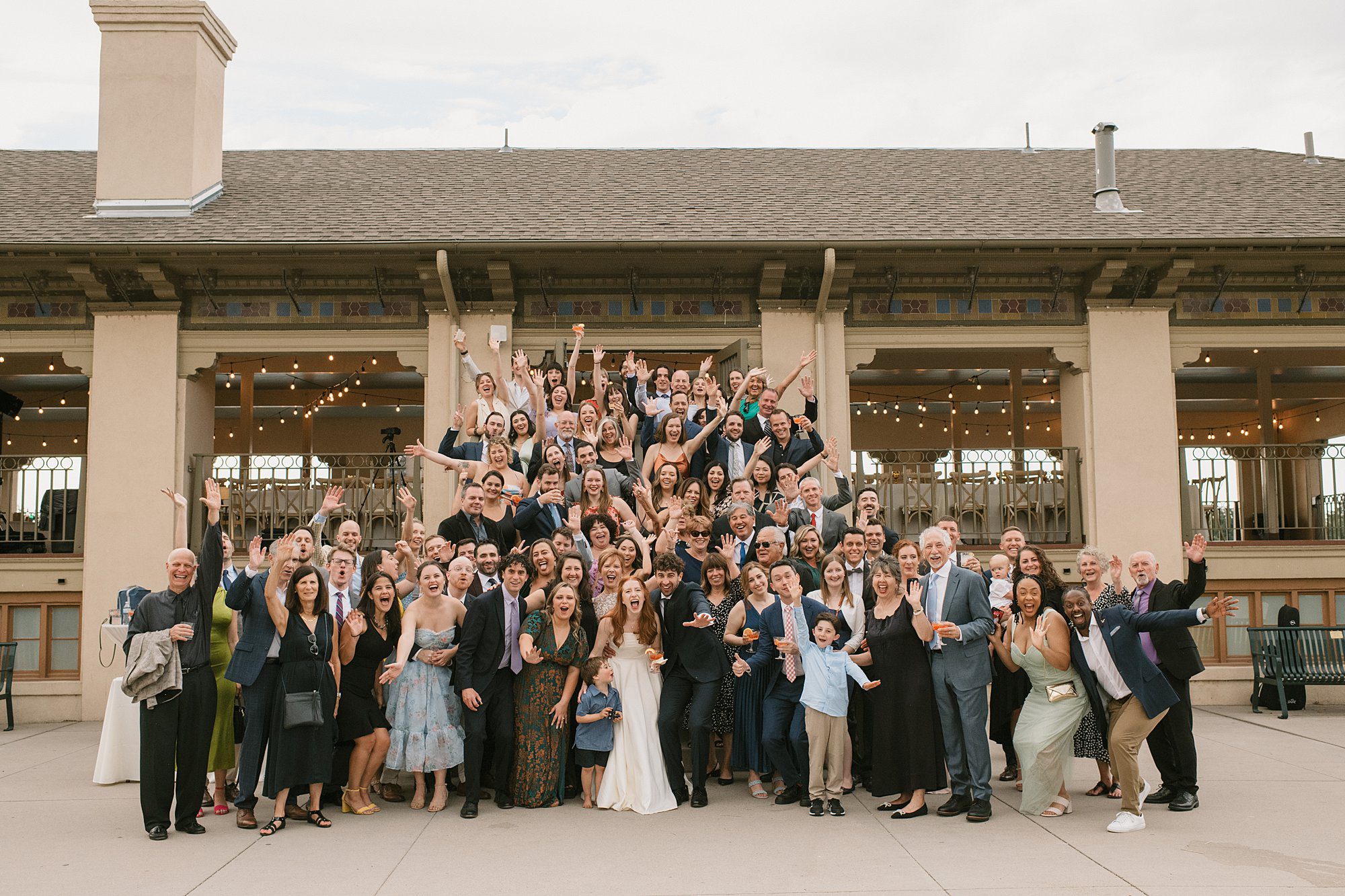 a group photo of all the guests on the steps of the Washington Park Boathouse