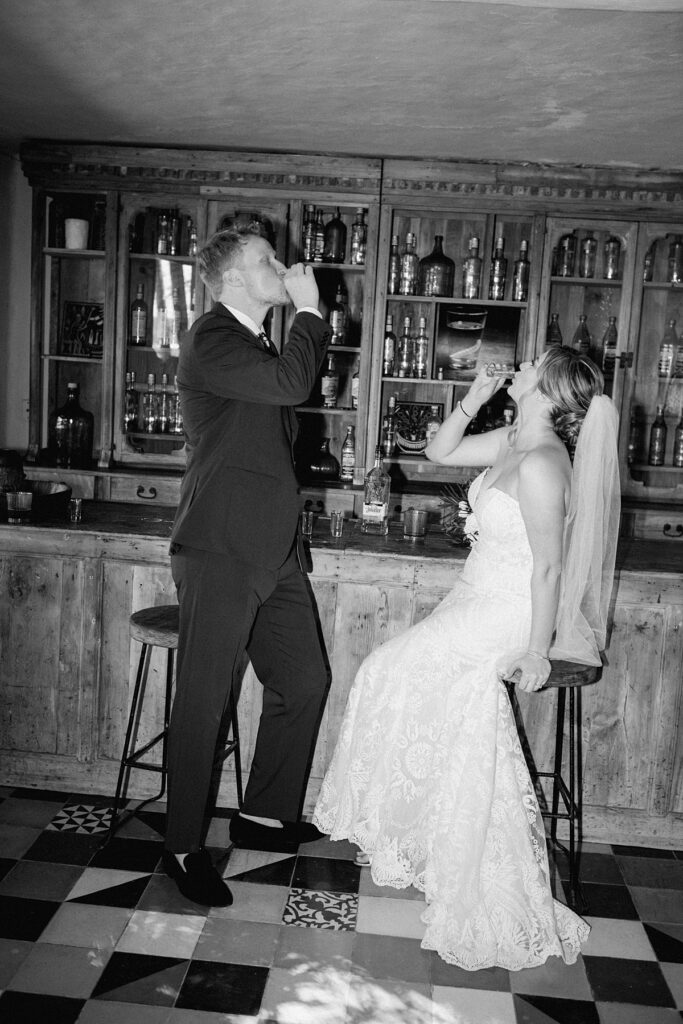 a bride and groom take a shot of tequila during their private island mexico wedding 