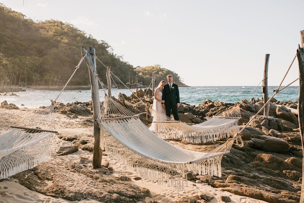 a bride and groom in the hammocks on the beach of their private island mexico wedding venue