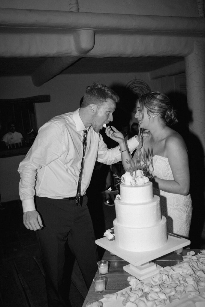 a bride and groom cut their wedding cake at a private island mexico wedding venue