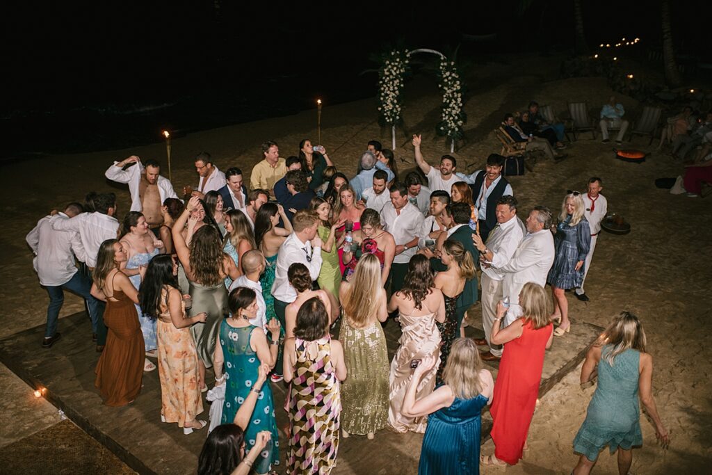 guests party on their private beach during a Mexican wedding ceremony