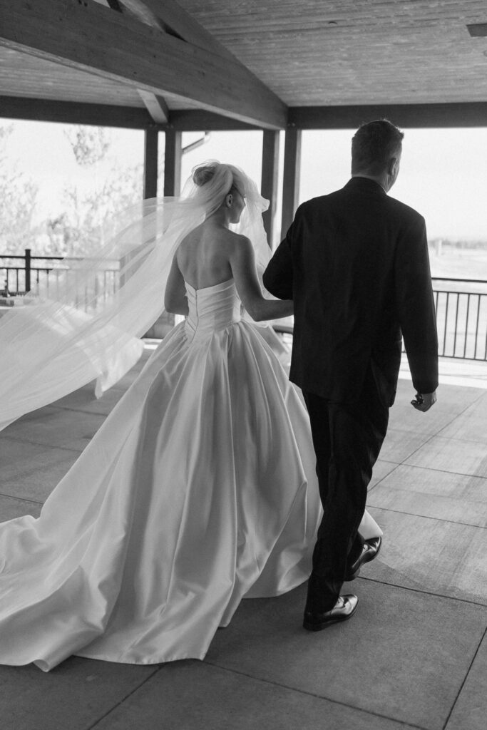 a bride and her father walk down the aisle for her TPC Colorado wedding
