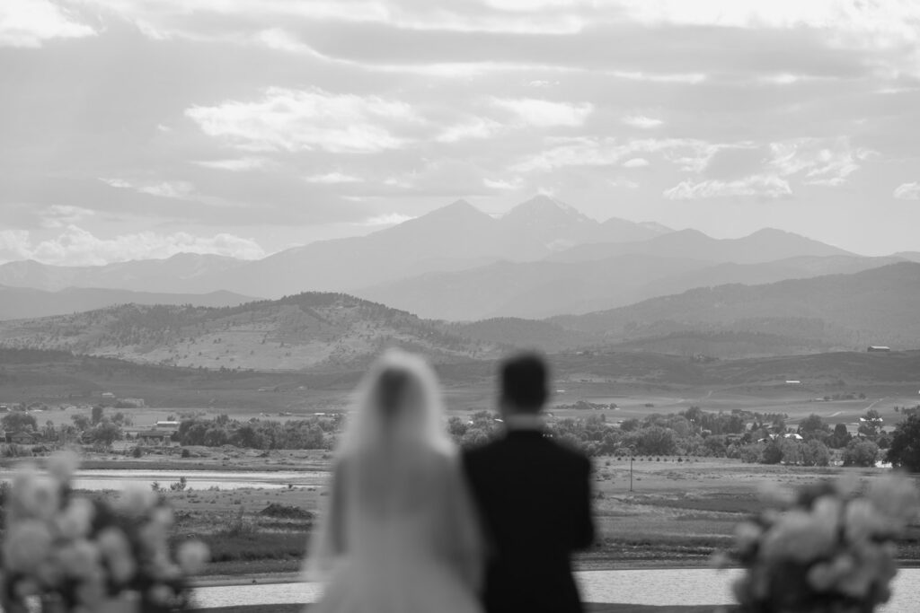 a bride and groom stand during their wedding TPC Colorado wedding in front of Long's Peak